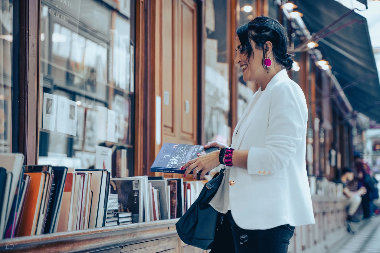 Carmen Gerea explorando libros en una galería de París